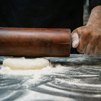 Person Using Brown Wooden Rolling Pin