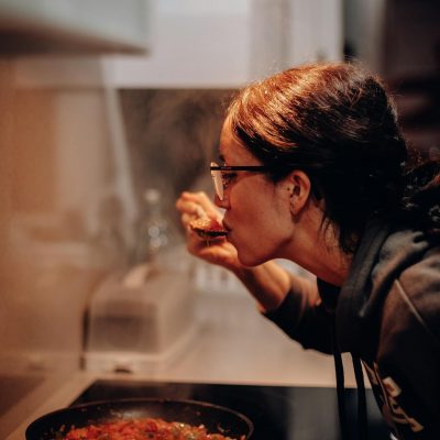 Woman Eating on Cooking Pan